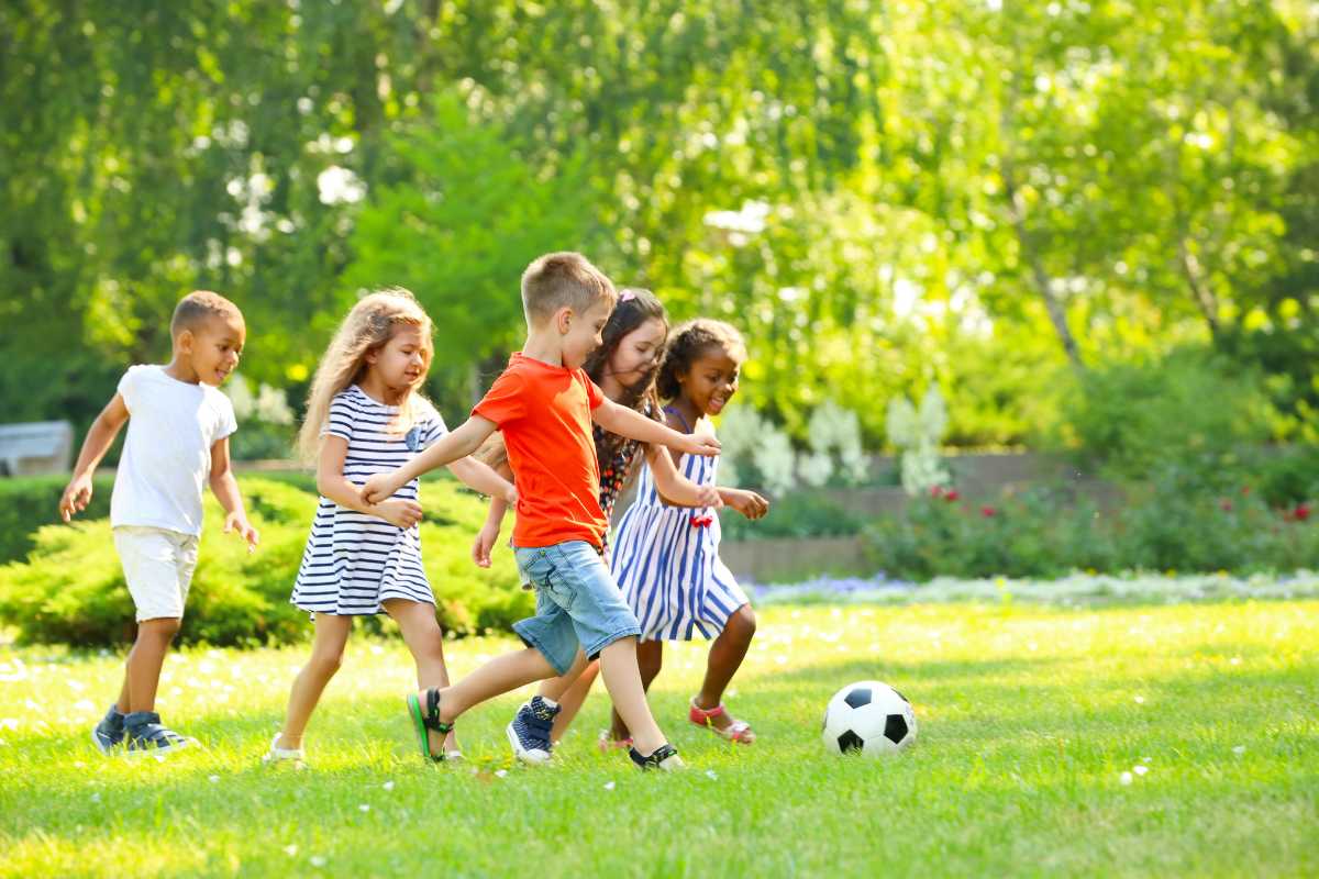 Vista panoramica della Certosa di Pavia con bambini che giocano nel parco