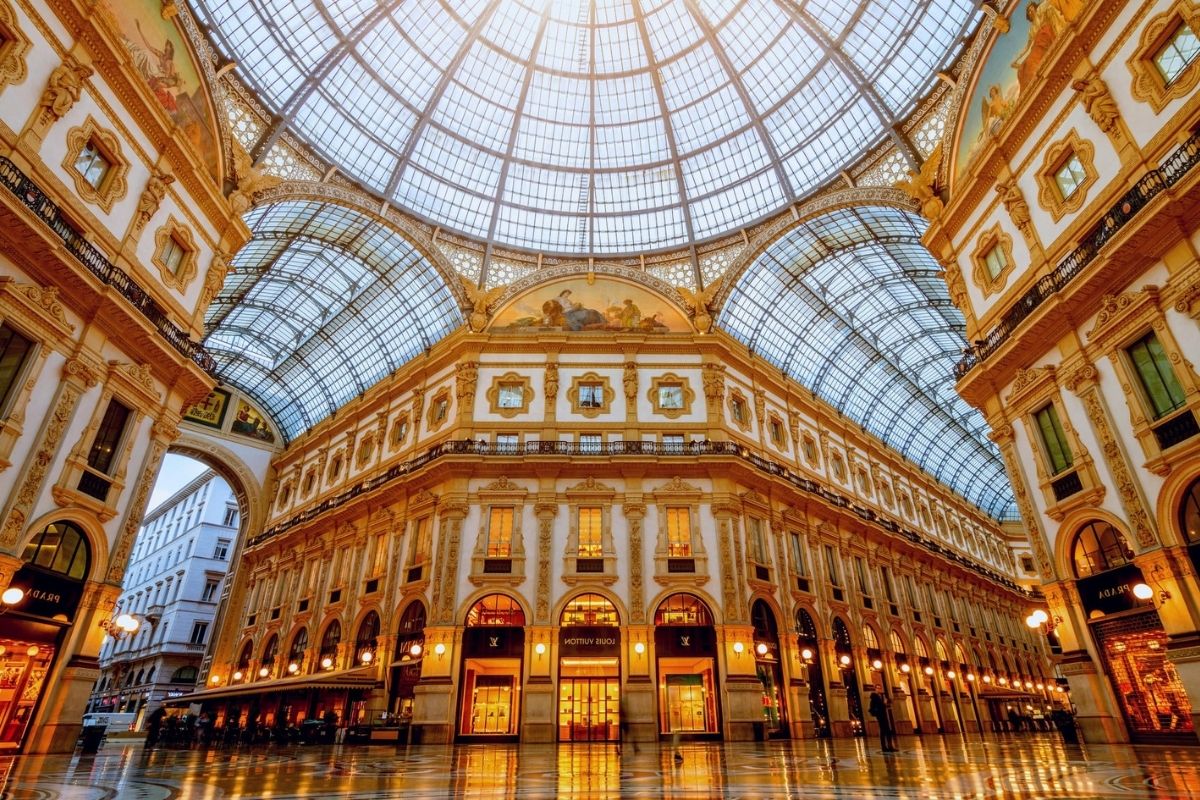 Interno della Galleria Vittorio Emanuele II, evidenziare l'atmosfera e i negozi di lusso